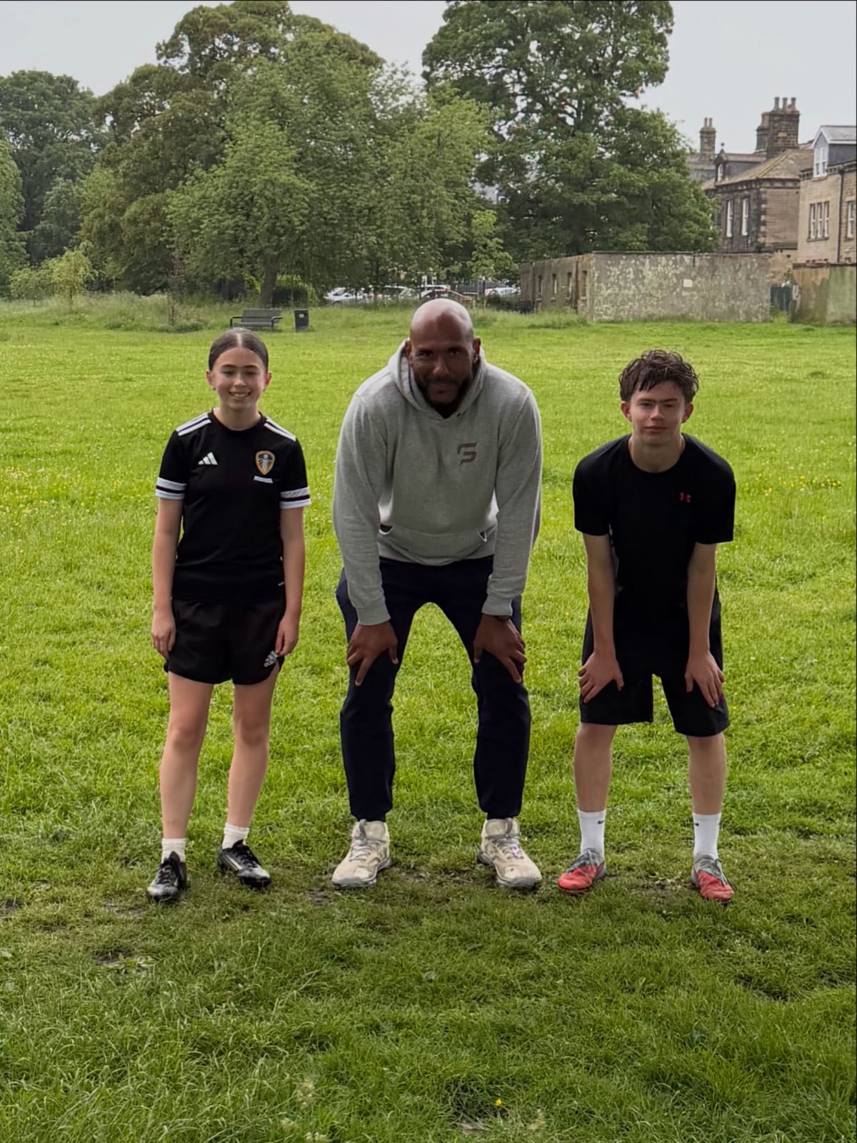 Tim Abeyie coaching sprint stance with two young athletes