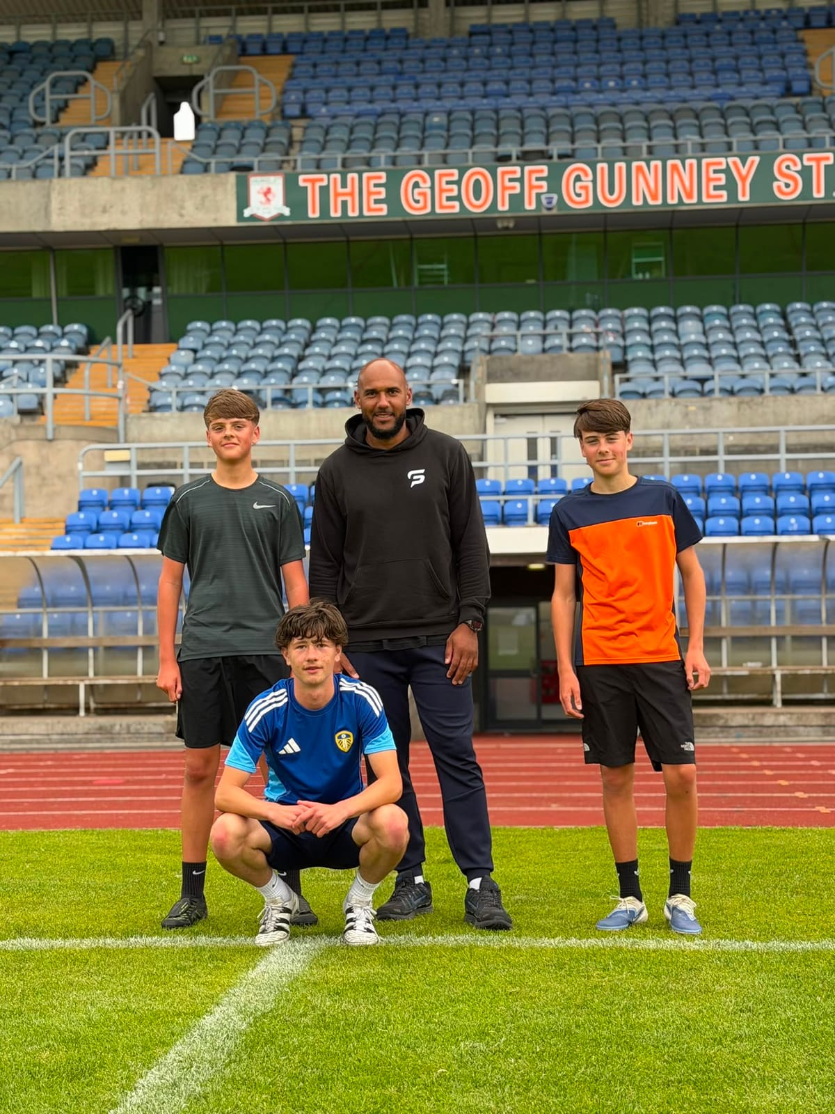 Tim Abeyie with young athletes at the stadium